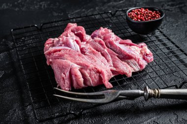 Raw Turkey sliced fillet meat ready for cooking. Black background. Top view.