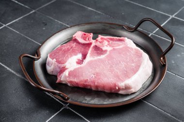 Raw pork t bone chop meat steak. Black background. Top view.