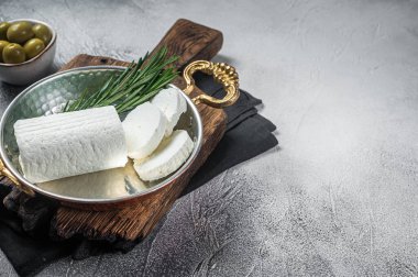 Goat soft cheese chevre in a skillet. White background. Top view. Copy space.