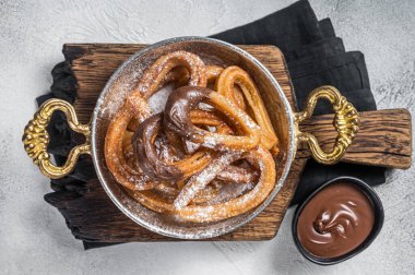 Çikolatalı Churros tavada tipik İspanyol tatlı atıştırmalığı. Gri arka plan. Üst görünüm.