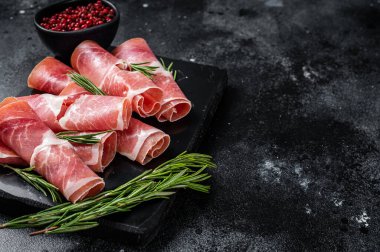 Geleneksel İspanyol Jamon Serrano jambonu mermer tahtada. Siyah arka plan. Üst Manzara. Boşluğu kopyala.