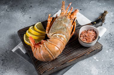 Cooked Spiny lobster or sea crayfish on a wooden board. Gray background. Top view.
