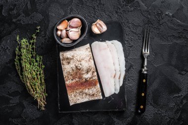 Mermer tahtada sarımsak ve karabiber dilimlenmiş tuzlu domuz yağı. Siyah arka plan. Üst görünüm.