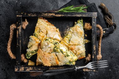 Ispanaklı turta, ahşap tepside Spanakopita Yunan turtası. Siyah arka plan. Üst görünüm.