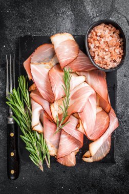 Domuz Black Forest Jambon Dilimleri mermer tahtada. Siyah arka plan. Üst görünüm.