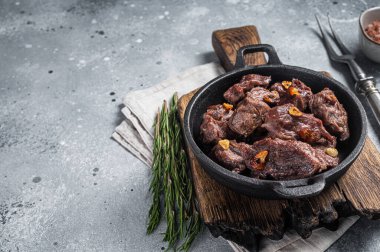 Grilled Sauteed Diced Beef in a skillet with garlic. Gray background. Top view. Copy space.