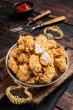 Ev yapımı patlamış mısır tavuğu tavada ısırığı. Ahşap arka plan. Üst görünüm.