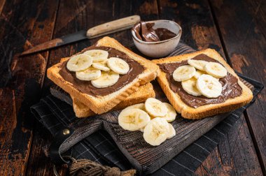 Tahtada muz ve çikolata kremalı tost ekmeği. Ahşap arka plan. Üst görünüm.