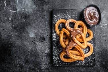 Geleneksel Meksika usulü çikolatalı churros. Siyah arka plan. Üst Manzara. Boşluğu kopyala.