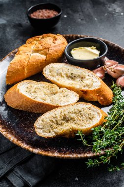 Salt, Pepper, Thyme ve zeytinyağlı sarımsaklı baget. Siyah arka plan. Üst görünüm.