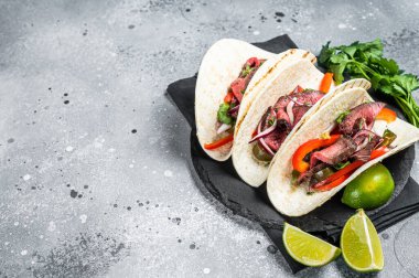 Homemade Mexican Steak Steet Tacos with Cilantro, green sauce, jalapenos and onion. Gray background. top view. copy space.