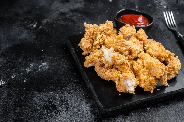 Kızarmış kızarmış ekmek kırıntısı, tavukla kaplı ketçaplı patlamış mısır. Siyah arka plan. Üst Manzara. Boşluğu kopyala.