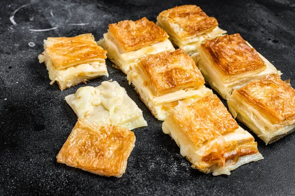 Turkish Su Boregi, Tabla borek or burek with cheese. Black background. Top view.