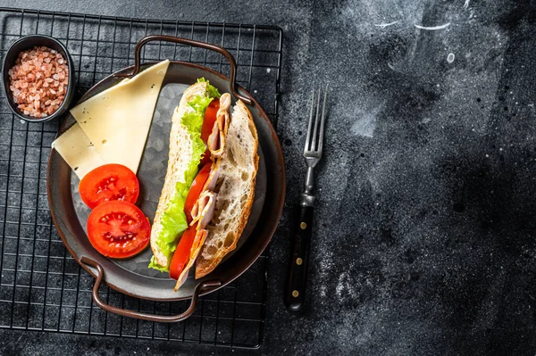 Deli meat sandwich with turkey ham, cheese, tomato and Lettuce. Black background. Top view. Copy space.
