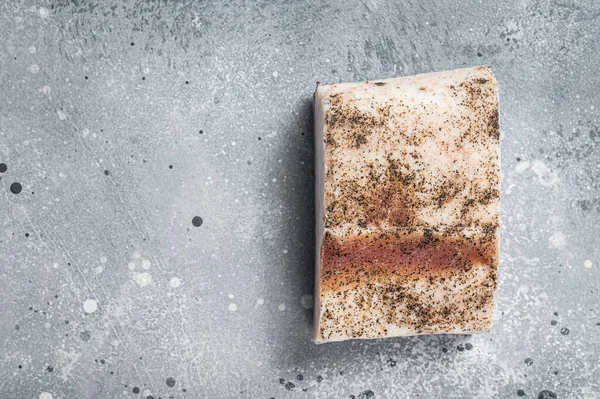 Salty lard with garlic and black pepper. Gray background. Top view. Copy space.