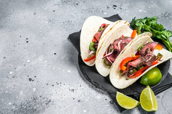 Homemade Mexican Steak Steet Tacos with Cilantro, green sauce, jalapenos and onion. Gray background. top view. copy space.