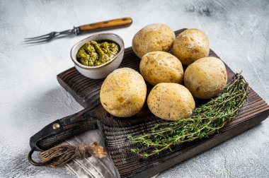 Canary Islands dish Papas Arrugadas, wrinkly potatoes with Mojo verde green sauce. White background. Top view.