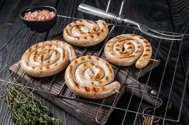 Izgarada ızgara domuz etli sosis ızgara. Siyah arka plan. Üst görünüm.