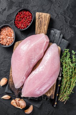 Pişmemiş çiğ hindi göğsü fileto ve şifalı biftek. Siyah arka plan. Üst görünüm.