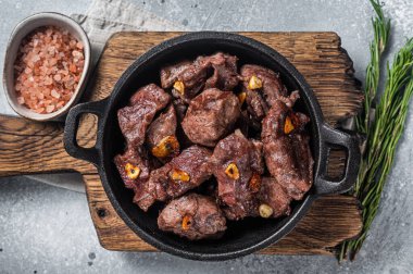 Sarımsaklı tavada ızgara Sauteed Beef. Gri arka plan. Üst görünüm.