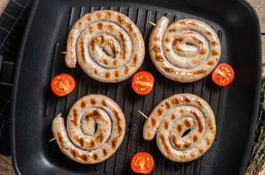 Baharatlı ızgara tavada kızartılmış et sosisi. Ahşap arka plan. Üst görünüm.