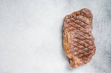 Grilled New York striploin beef meat steak. White background. Top view. Copy space.