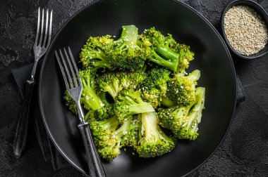 Baharatlı haşlanmış brokoli. Siyah arka plan. Üst görünüm.