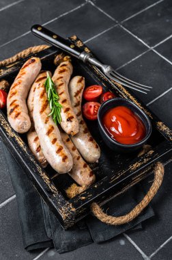Grilled Bratwurst meat sausages with herbs and spices. Black background. Top view.