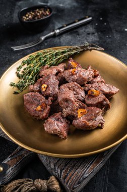 Dilimlenmiş ızgara biftek sarımsaklı biftek ve kekik. Siyah arka plan. Üst görünüm.