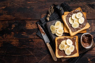 Tahtada muz ve çikolata kremalı tost ekmeği. Ahşap arka plan. Üst Manzara. Boşluğu kopyala.