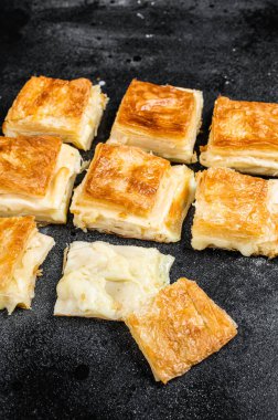 Turkish Su Boregi, Tabla borek or burek with cheese. Black background. Top view.