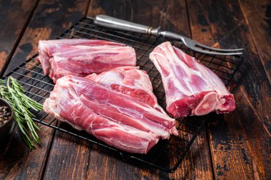 Raw lamb shanks with herbs and spices ready for cooking. Wooden background. Top view.