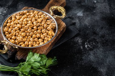Kızarmış nohut, kızartılmış baharatlı nohut ya da Hint chana 'sı ya da tavada chole. Siyah arka plan. Üst Manzara. Boşluğu kopyala.