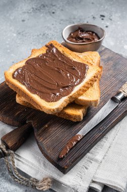 Tahtaya sürülmüş çikolatalı fındıklı tost. Gri arka plan. Üst görünüm.