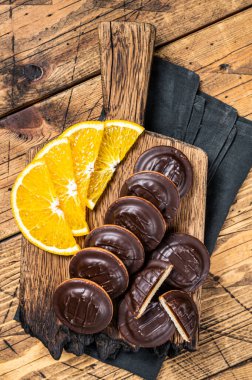 Chocolate Jaffa Cakes with Orange Flavored Marmalade. Wooden background. Top view.
