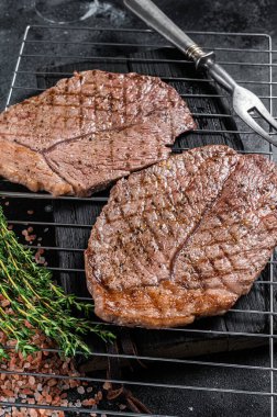 Barbekü ızgara sığır eti bifteği ve ızgarada sığır eti. Siyah arka plan. Üst görünüm.