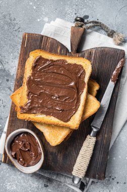 Tahtaya sürülmüş çikolatalı fındıklı tost. Gri arka plan. Üst görünüm.