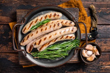 Sausages fried with spices and herbs, meat Bratwurst. Wooden background. Top view.
