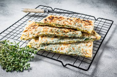 Gozleme Turkish stuffed pastrie, flatbread with greens and cheese. White background. Top view.