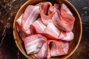 Ahşap tabakta tütsülenmiş pastırma. Karanlık arka plan. Üst görünüm.