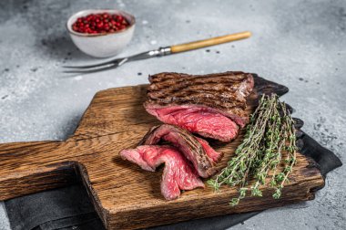 BBQ Grilled Wild Venison steak on wooden board. Gray background. Top view.