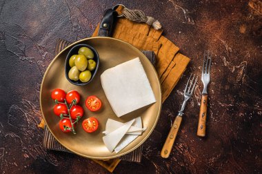 Zeytin ve domatesli bir tabakta keçi peyniri. Karanlık arka plan. Üst görünüm.