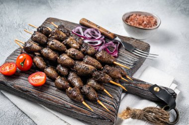 Chicken hearts grilled on skewers with herbs and spices. White background. Top view.