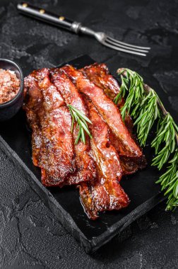 Kızarmış, çıtır çıtır domuz pastırması. Siyah arka plan. Üst görünüm.