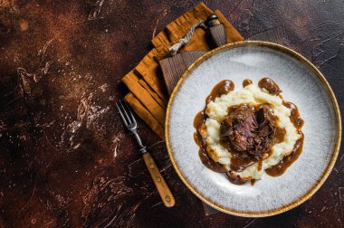 Kırmızı şarap soslu ve patates püresiyle yavaş pişmiş sığır eti yanakları. Karanlık arka plan. Üst Manzara. Boşluğu kopyala.