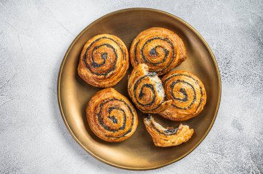 Poppy seed rolls and cardamom buns, Traditional Nordic baked sweet breads on wooden board. White background. Top view.