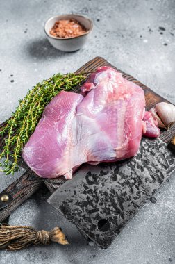 Poultry fresh meat, Raw Turkey thigh fillet on wooden cutting board. Gray background. Top view.