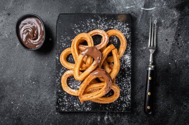 Geleneksel Meksika usulü çikolatalı churros. Siyah arka plan. Üst görünüm.