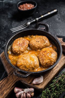 Tavada domates soslu ton balıklı balık köftesi. Siyah arka plan. Üst görünüm.