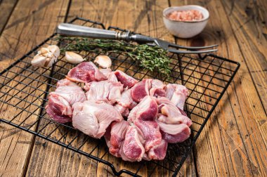 Fresh Raw chicken stomachs, gizzards on a grill ready for cooking with herbs. Wooden background. Top view.